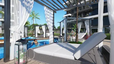 Luxurious Modern Outdoor Pool Area with Cabanas. Modern resort-style outdoor pool area with clear blue water, stylish grey sun loungers, and white-curtained pergolas. Features lush palm trees and people enjoying the amenities.