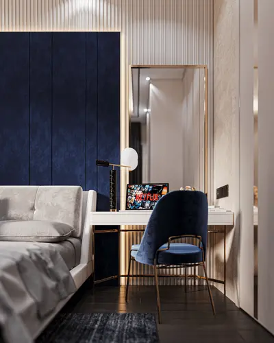 Stylish Bedroom with Blue Velvet Wall and Integrated Workspace. A modern bedroom with dark wood flooring, a plush bed, and a bold blue velvet accent wall. Features an elegant white desk, gold-trimmed mirror, and blue velvet chair.