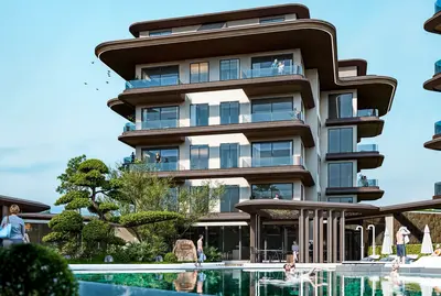 Luxury Residential Building with Pool and Landscaped Gardens. Exterior view of a modern luxury residential complex featuring a multi-story building with numerous balconies, a large outdoor swimming pool, and lush landscaped gardens, all under a clear sky.