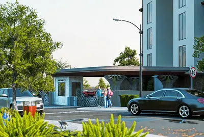 Modern Gated Community Entrance with Security Booth. A modern residential complex entrance featuring a security booth, barrier gate, parked cars, and lush green landscaping, highlighting a secure and well-maintained property.
