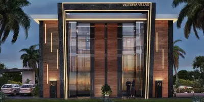 Luxury Victoria Villas Entrance Exterior at Dusk. The elegant exterior of Victoria Villas features modern dark marble, wood paneling, and illuminated LED strips. A grand glass entrance is flanked by lush palm trees and a manicured garden at dusk.