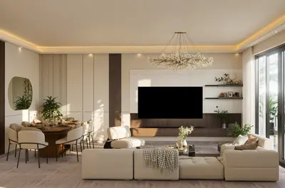 Elegant Open-Plan Living and Dining Space. A spacious, modern open-plan living room and dining area featuring a cream sectional sofa, large TV, and elegant chandelier. Light flooring and large glass doors create a bright, inviting space.