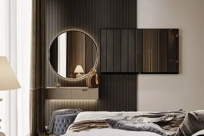 Stylish Modern Bedroom with Illuminated Mirror and TV. A modern bedroom with a chic dressing area featuring a backlit round mirror, floating vanity, and wall-mounted TV. Luxurious bedding and dark paneling complete the elegant design.