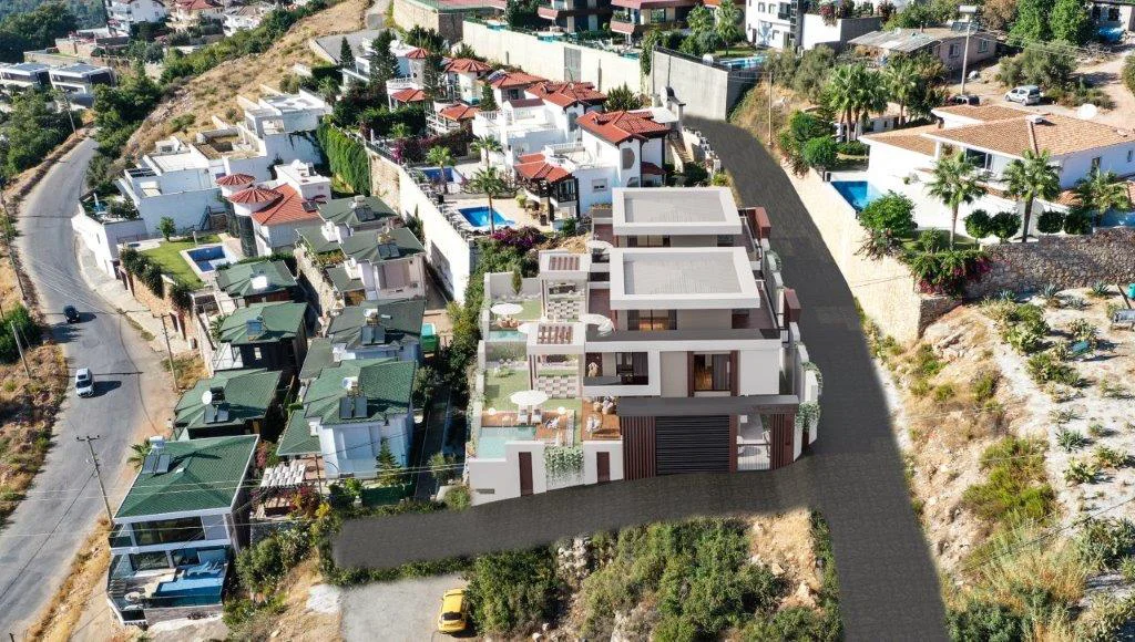 Moderne rækkehusbebyggelse med private pools. Luftfoto af et moderne terrasseret boligkompleks med flere hvide villaer, private pools, udendørs siddepladser og frodig beplantning, beliggende på en skråning.