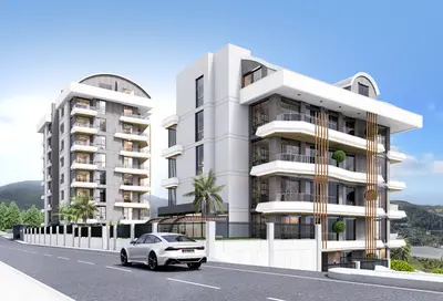 Moderni apartmanski objekti eksterijer sa balkonima i zelenilom. Vanjski pogled na dvije moderne stambene apartmanske zgrade. Savremeni dizajn uključuje više balkona, velike prozore i elegantnu fasadu u sivoj i bijeloj boji. U prednjem planu se vide put i pejzaž.