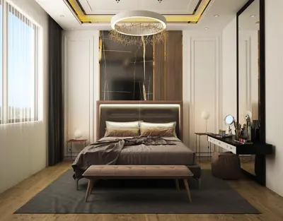 Elegant Master Bedroom with Modern Design and Luxurious Finishes. Modern master bedroom with a large bed, illuminated headboard, and a dark marble accent wall. Features include a vanity with mirror, wood flooring, and a decorative chandelier.