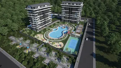 Modern Residential Complex with Pool, Tennis Court, and Playgrounds. An aerial view of a modern residential complex featuring two sleek apartment buildings, a large lagoon-shaped swimming pool, a tennis court, and multiple green playgrounds, surrounded by lush trees.