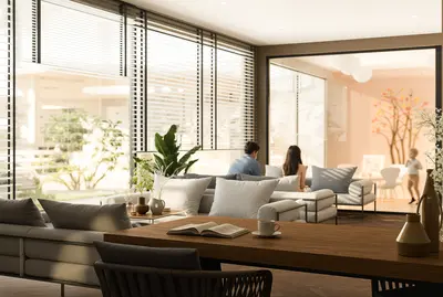 Spacious Contemporary Living Area with Garden View. A bright and spacious modern living room featuring large windows, wooden flooring, and a comfortable grey sofa. Natural light floods the contemporary space, offering a view of a lush garden.